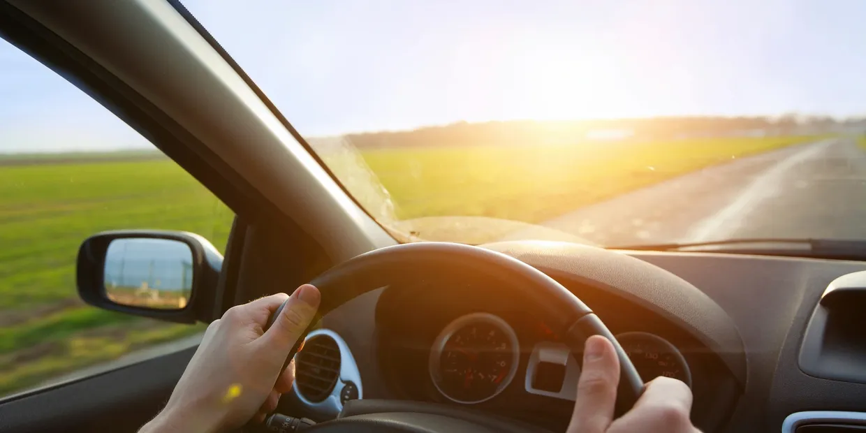 Hands of car driver on steering wheel